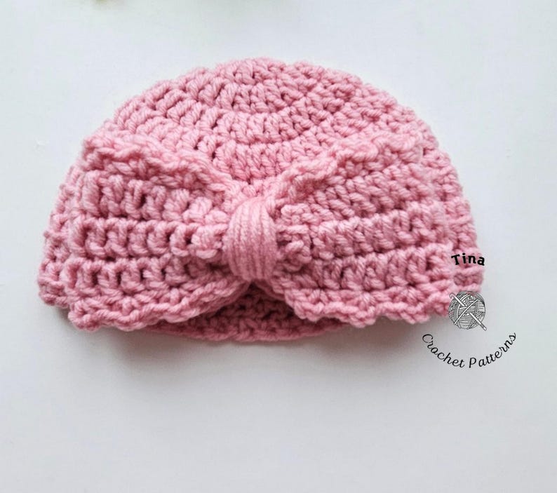 May include: A light pink crochet turban-style hat with a knotted bow detail. The hat is handmade with a textured stitch and features the text "Tina" and "Crochet Patterns".
