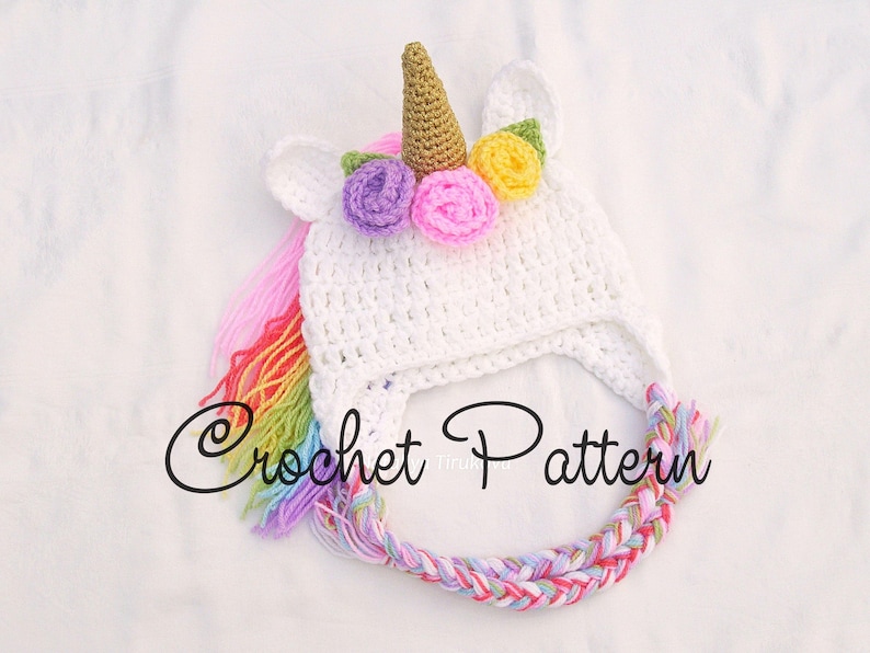 Peut inclure: Chapeau de licorne en crochet blanc avec une crini&egrave;re arc-en-ciel et une corne avec des fleurs color&eacute;es. Mod&egrave;le de crochet.