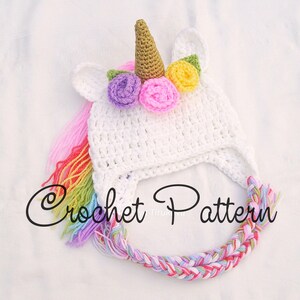 Peut inclure: Chapeau de licorne en crochet blanc avec une crini&egrave;re arc-en-ciel et une corne avec des fleurs color&eacute;es. Mod&egrave;le de crochet.
