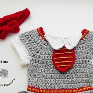 May include: A gray crocheted baby outfit with a red and yellow trim. The outfit has a white crocheted collar and a red crocheted tie with yellow stripes. The outfit is accompanied by a red crocheted headband with a bow.