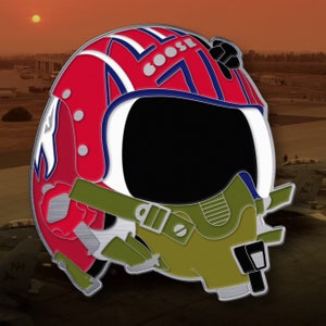 May include: A red, white, and blue pilot helmet with a green oxygen mask. The helmet has the word "GOOSE" written on the side.