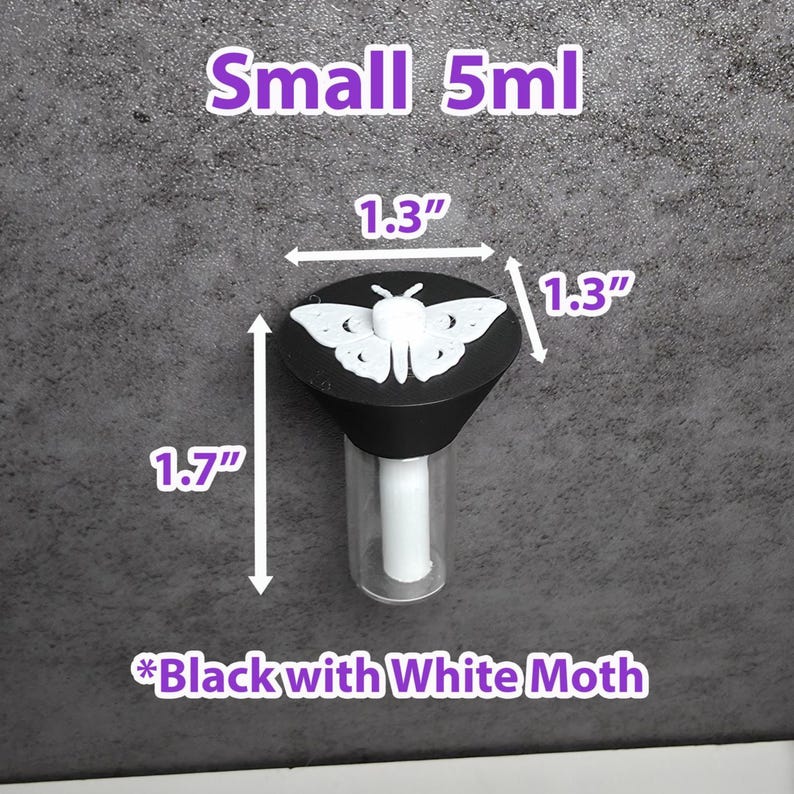 May include: A small, clear glass bottle with a black cap featuring a white moth design. The bottle is 4.3 cm tall, and the cap is 3.3 cm in diameter. The text "Small 5ml" and "Black with White Moth" are also visible.