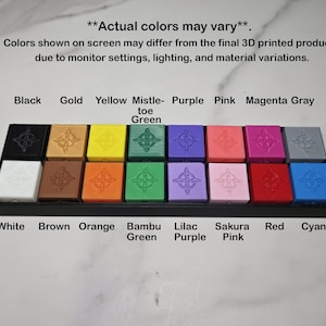 May include: A display of 20 colourful, square 3D-printed objects in a black tray. Colours include black, gold, yellow, mistletoe green, purple, pink, magenta, grey, white, brown, orange, bambu green, lilac purple, sakura pink, red, and cyan.
