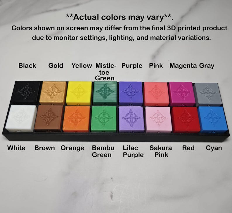 May include: A display of 20 colourful, square 3D-printed objects in a black tray. Colours include black, gold, yellow, mistletoe green, purple, pink, magenta, grey, white, brown, orange, bambu green, lilac purple, sakura pink, red, and cyan.