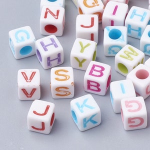 May include: Assortment of white letter beads with colourful paint. The letters include G, H, J, K, N, S, V, W, Y, and Z.
