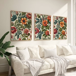 May include: Three framed floral prints with a white background and colorful flowers. The prints are arranged in a row on a white wall.