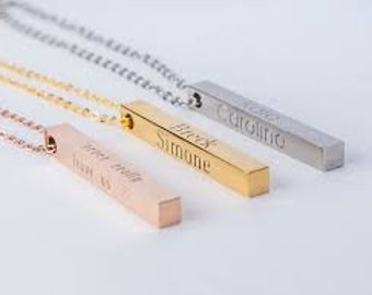 May include: Three gold, silver, and rose gold bar necklaces with personalized names engraved on them. The necklaces are on a white background.