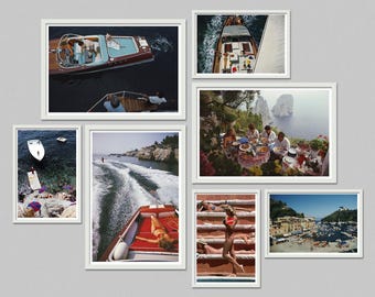May include: A collection of framed photographs featuring scenes of leisure and travel. Images include boats on the water, people sunbathing, and a group dining outdoors. The color palette is vibrant, with blues, reds, and greens.