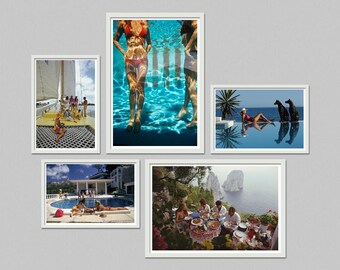 May include: A collection of framed art prints featuring vacation scenes. Images include people on a sailboat, in a pool, sunbathing, and dining outdoors. The prints are in white frames, creating a cohesive gallery wall.