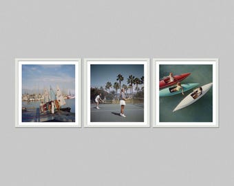 May include: Set of three framed prints. The left print shows sailboats in a harbor. The center print depicts people playing tennis. The right print features people in kayaks and a red boat on the water. All prints have a white border.