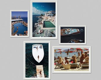 May include: A collection of framed photographs featuring scenes of leisure and travel. Images include a pool, a boat, and a beach with people. The frames are white, and the background is a neutral gray.