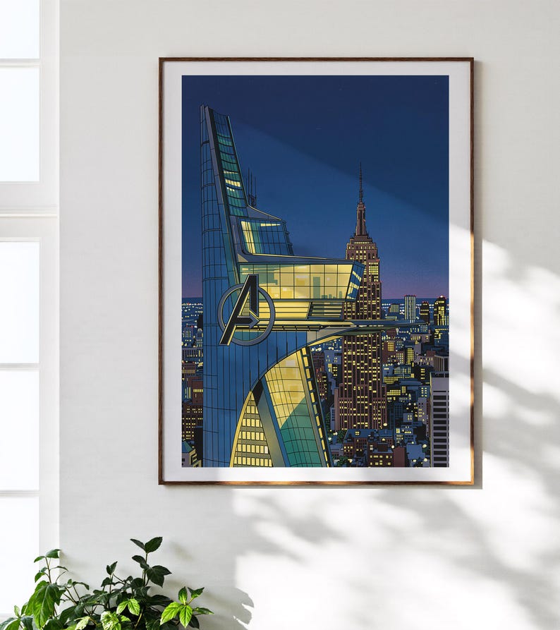 Op de afbeelding: Ingelijste kunstdruk met een gestileerde illustratie van een stadsgezicht 's nachts. Het kunstwerk toont een moderne wolkenkrabber met het Avengers-logo, naast het Empire State Building. Het kleurenpalet omvat blauw, geel en oranje.