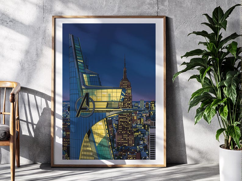 Op de afbeelding: Een ingelijste kunstdruk met een gestileerd stadsbeeld in de schemering. Het kunstwerk toont een moderne wolkenkrabber met het Avengers-logo, het Empire State Building en een levendige skyline onder een diepblauwe hemel. De print zit in een houten lijst.