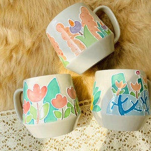 Unique handcrafted ceramic mug with colorful flower pattern.