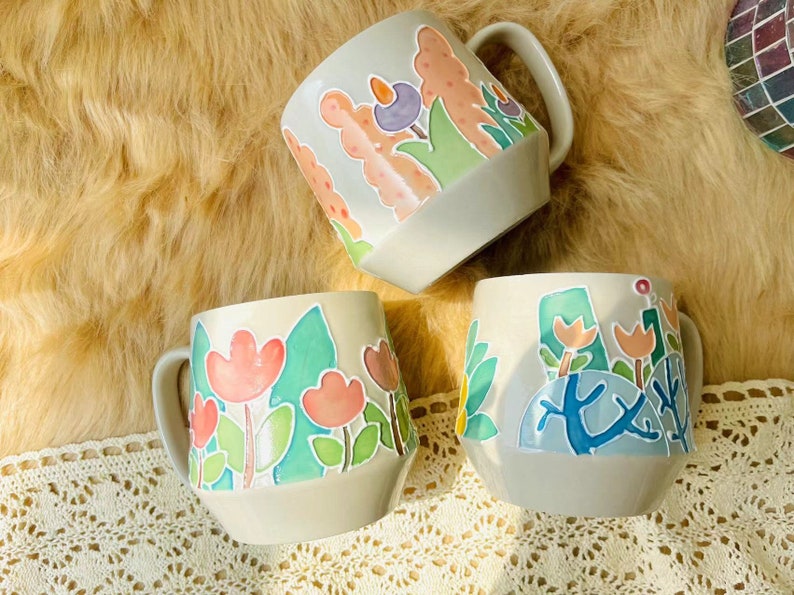 Unique handcrafted ceramic mug with colorful flower pattern.