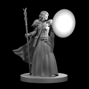 May include: A gray figurine of a woman wearing a long robe and holding a staff and a glowing orb. The figurine is standing on a round base.