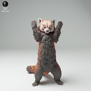 May include: A red panda figurine standing on its hind legs with its arms raised in the air. The figurine is made of painted resin and has a realistic appearance.