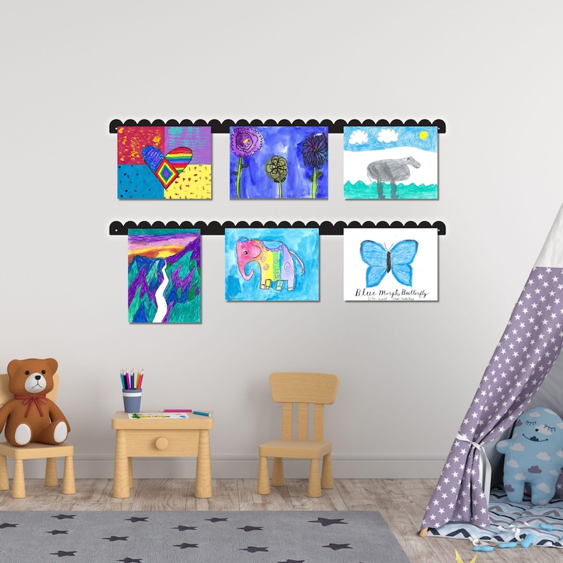 Scalloped metal kids art display board mounted on wall, featuring two rails with six colorful children’s drawings held by pushpin magnets. Handmade in the USA, this kids artwork display is ideal for playroom wall art, kids room decor, or homeschool spaces. Perfect as a kids magnet board, kids drawing display, or artwork display sign. A fun and functional playroom decor sign that turns creativity into cherished decor. Great gift for parents or grandparents to showcase art.