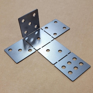 May include: A set of six metal corner brackets with multiple holes for attaching to surfaces. The brackets are arranged in a T-shape.