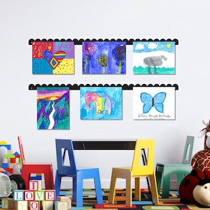 Wall mounted metal kids artwork display featuring two scalloped rails holding six colorful drawings with included magnets. Handmade in the USA, this kids art display board is perfect for showcasing creativity in a playroom or classroom. Ideal as a kids magnet board, kids drawing display, or artwork display sign. A charming addition to playroom decor, kids room decor, or homeschool walls. Makes a heartfelt kids artwork display for parents and grandparents to enjoy.