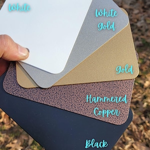 Powder coated color options for handmade metal kids art display boards, including white, white gold, gold, hammered copper, and black. Ideal for customizing your kids magnet board, art display board, or artwork display sign. Choose a finish to match your playroom decor, kids room decor, or classroom space. Each kids artwork display is made in the USA and perfect for showcasing drawings, crafts, and creations with a personalized touch.