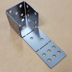 May include: A set of five metal corner brackets with multiple holes for attaching to a surface. The brackets are made of a silver-colored metal and are arranged in a line.