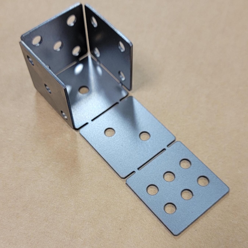 May include: A set of five metal corner brackets with multiple holes for attaching to a surface. The brackets are made of a silver-colored metal and are arranged in a line.