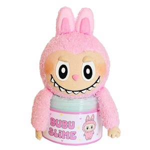 May include: A pink plush toy shaped like a monster with bunny ears, holding a jar of slime. The jar is labeled "BUBU SLIME" with a cartoon character illustration. The toy has a light brown face, large eyes, and a toothy grin.