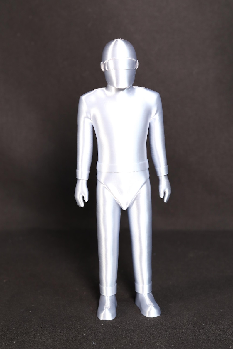 May include: A silver-colored, 3D printed figurine of a person wearing a helmet and a full-body suit.