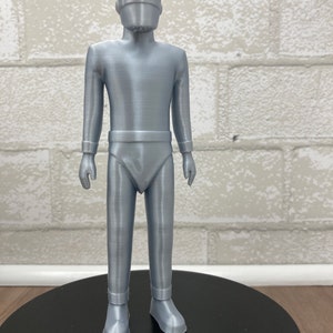 May include: A silver-colored 3D printed figurine of a robot with a helmet and a futuristic design.