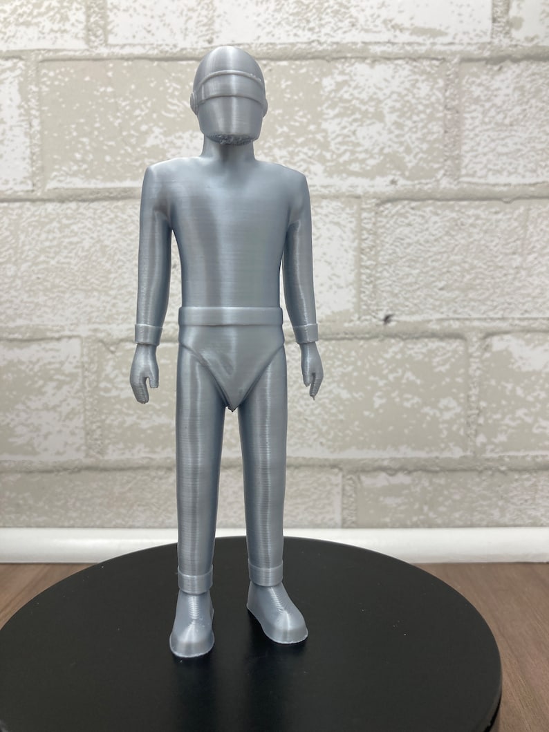 May include: A silver-colored 3D printed figurine of a robot with a helmet and a futuristic design.