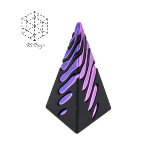May include: A black, pyramid-shaped decorative object with a gradient of purple and blue on the top surface. The design includes cut-out shapes and the text "RJ Design" next to a geometric shape.