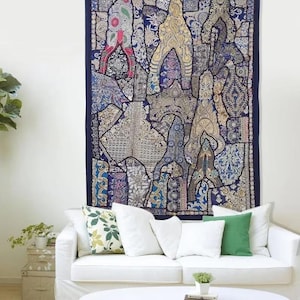 Op de afbeelding: Een rechthoekig wandkleed met een donkerblauwe rand en een centraal patchworkontwerp bestaande uit diverse stoffen segmenten in tinten blauw, goud, crème en wit, versierd met ingewikkeld borduurwerk en accenten van metaaldraad.