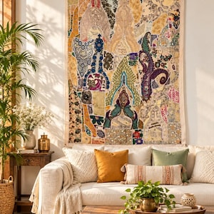 Puede incluir: Un gran tapiz rectangular para pared que presenta un mosaico de diversas telas en tonos oro, crema, azul, verde y morado. El tejido muestra intrincados bordados, abalorios y patrones de cachemira dispuestos en un diseño vertical.