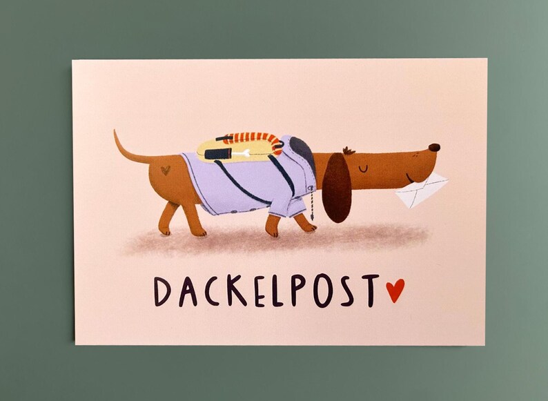 May include: A light pink greeting card featuring a brown dachshund wearing a light purple jacket and a yellow backpack with a striped strap. The dog carries a white envelope in its mouth. The text DACKELPOST and a red heart are printed below.
