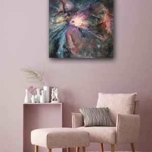 May include: A painting of a nebula in shades of pink, blue, and purple. The nebula is surrounded by a dark background with scattered stars.