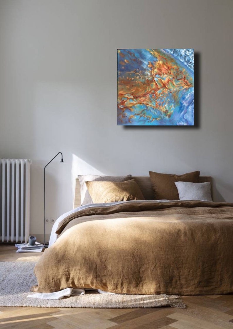 May include: Abstract painting with blue, brown, and gold colors. The painting is hanging on a wall above a bed with brown linen bedding.