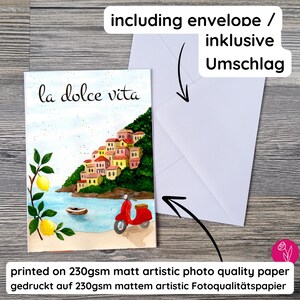 May include: A watercolor greeting card with the words "la dolce vita" and a coastal Italian village scene. The card includes a red scooter, lemons, and a white envelope. Printed on 230gsm matte artistic photo quality paper.