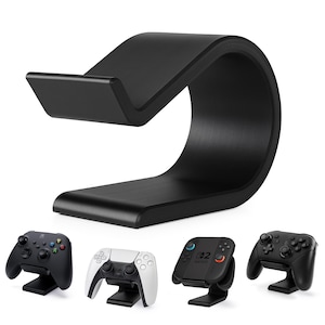 Può includere: Un supporto nero e curvo per controller di gioco. Il supporto ha un design a forma di onda ed è mostrato con diversi controller di gioco, tra cui un controller Xbox, un controller PlayStation e un controller Nintendo Switch. Il supporto è progettato per contenere i controller.