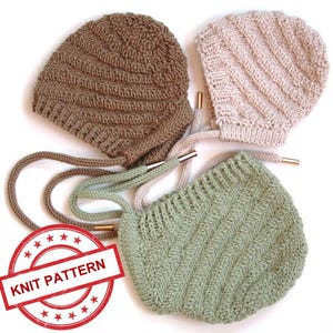 Puede incluir: Tres gorros de bebé tejidos en tonos marrón, rosa y verde, cada uno con un cordón y punteras metálicas. Los gorros presentan un diseño acanalado. Un sello rojo con las palabras "KNIT PATTERN" es visible.