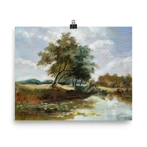 Unframed vintage style landscape, French countryside with river, soft blue sky and a tree. set against white wall.