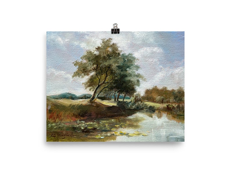 Unframed vintage style landscape, French countryside with river, soft blue sky and a tree. set against white wall.