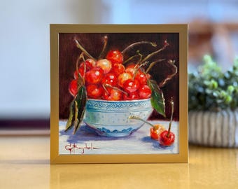 May include: A painting of a bowl filled with red cherries, with green leaves and stems. The bowl is white with blue and gold designs. The background is a dark brown.
