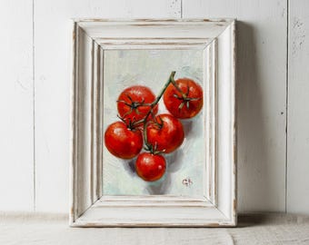 May include: A framed painting of a cluster of ripe red tomatoes on a vine. The tomatoes are depicted with realistic detail, showcasing their vibrant color and texture. The artwork is set against a light background and framed in a distressed white wooden frame.