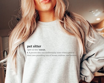 May include: Gray sweatshirt with the text "pet sitter /pet-si-ter/ noun. 1. A person who unconditionally loves others pets as their own providing lots of kisses, walkies, and treatos."
