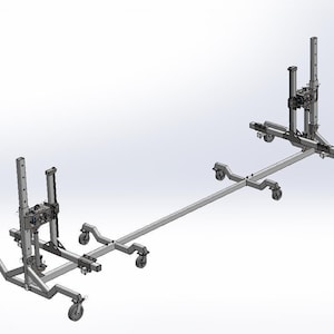 Puede incluir: Un par de soportes de elevación de coche plateados con ruedas, conectados por una barra de metal larga. Los soportes están diseñados para levantar y sostener un coche para reparaciones o mantenimiento.