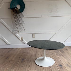 May include: A round, green marble top coffee table with a white pedestal base.