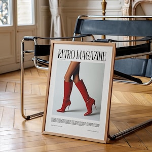 May include: A framed "Retro Magazine" print featuring a pair of legs in red high-heeled boots. The print has a wooden frame and is displayed on a wooden floor. The text on the print includes the magazine title and other text.