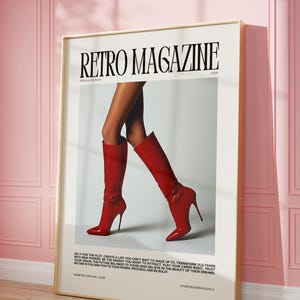 May include: A framed poster with the text "RETRO MAGAZINE" and the year 2025. The image features a pair of legs wearing shiny red high-heeled boots. The poster is displayed against a pink wall.