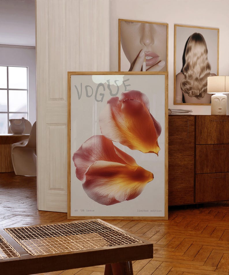 May include: A framed print featuring two large, abstract flower petals in shades of orange and pink. The word "VOGUE" is at the top, with "no '26 issue" and "limited edition" at the bottom. The print is displayed in a room with other framed art.